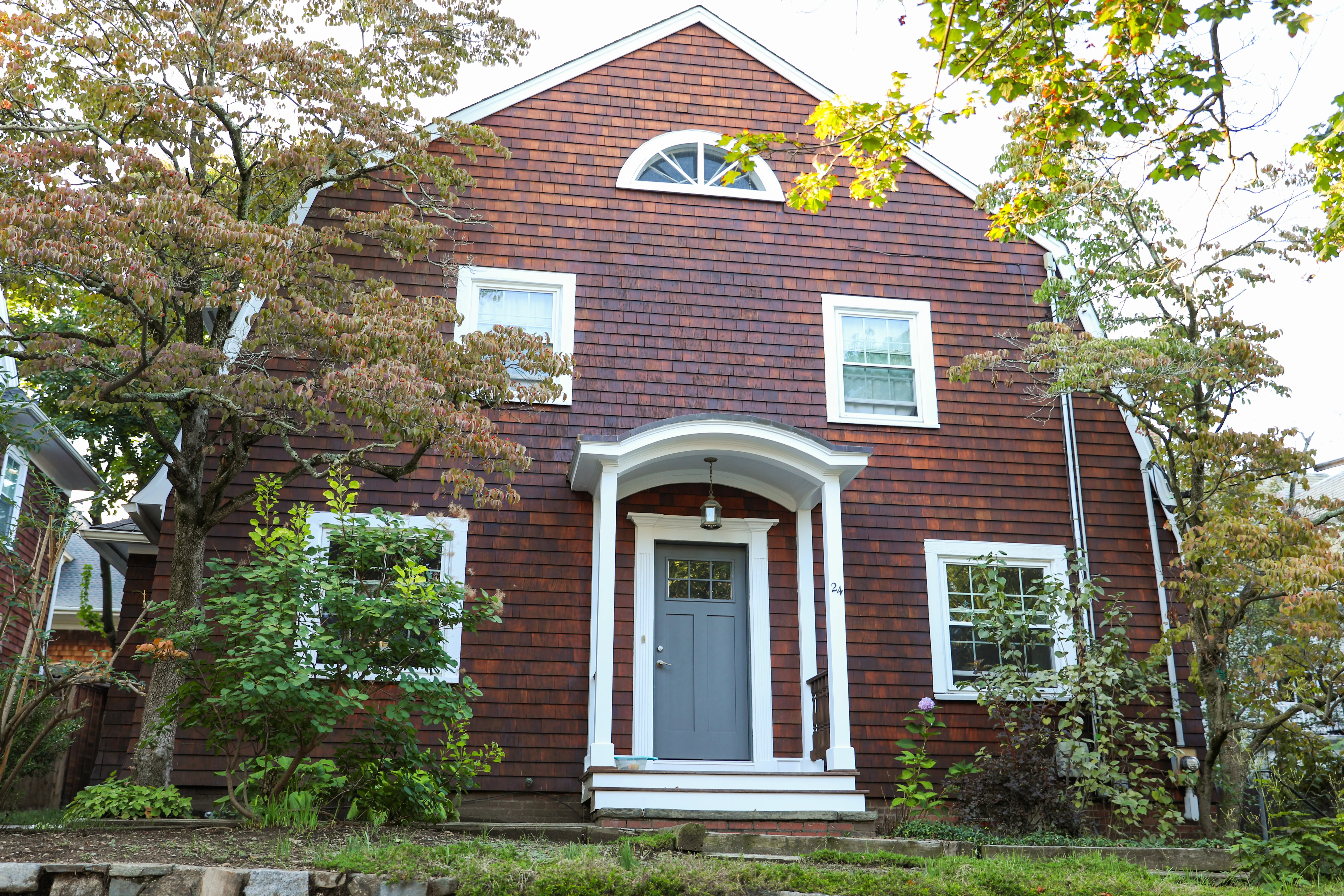 Ein Vorstadthaus unter sonnigem Himmel, das den amerikanischen Traum und die Herausforderungen steigender Hypotheken symbolisiert.