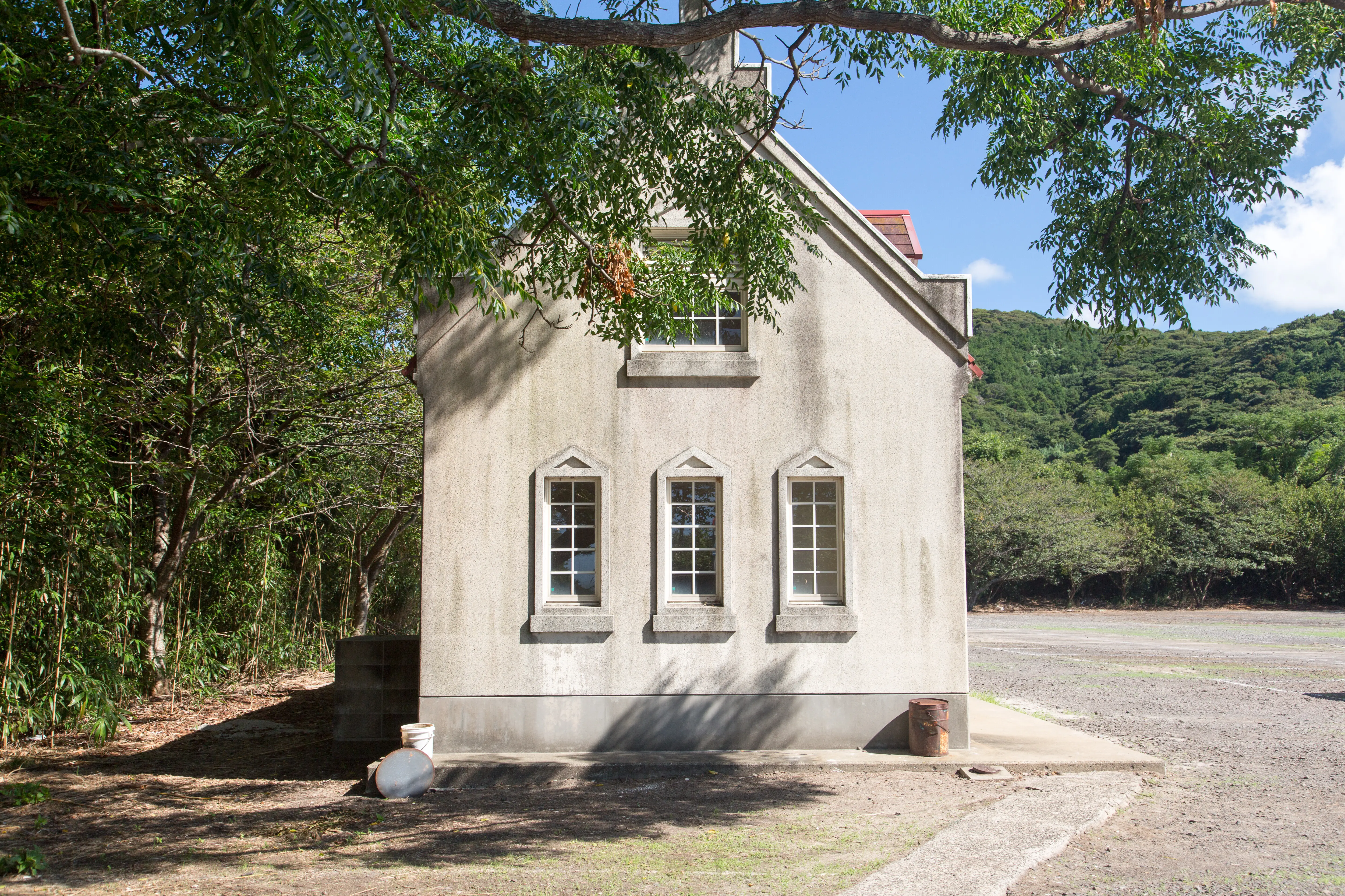 Außenansicht eines Gebäudes neben einem Baum vor dem Himmel.